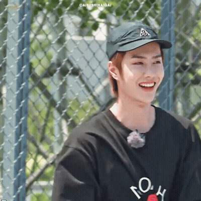 Young Man in Hat and Black Shirt Smiling