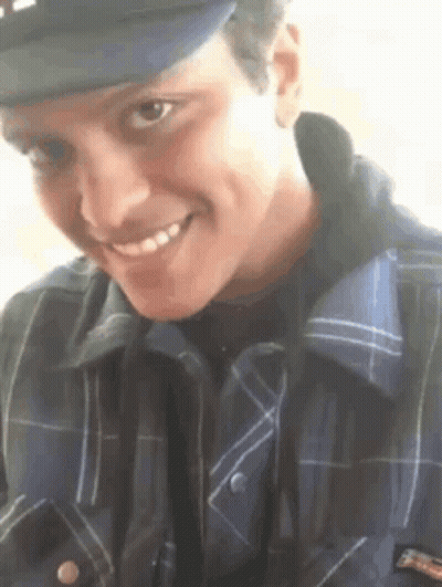 Young Man In Hat And Plaid Shirt Smiling GIF