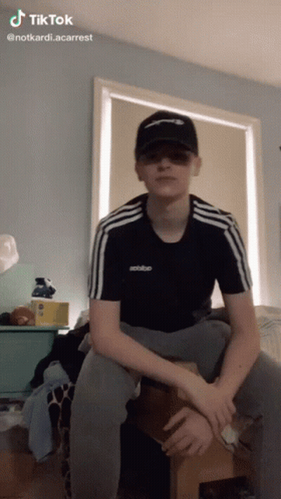 Young Man In Hat And Sunglasses Sitting On Wooden Box GIF