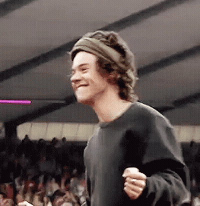 Young Man In Headband And Black Shirt Smiling In Crowd GIF