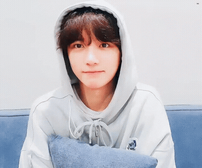 Young Man In Hoodie Sitting On Couch With Pillow GIF