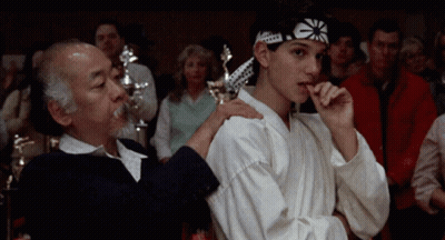 Young Man In Karate Headband Next To Older Man GIF