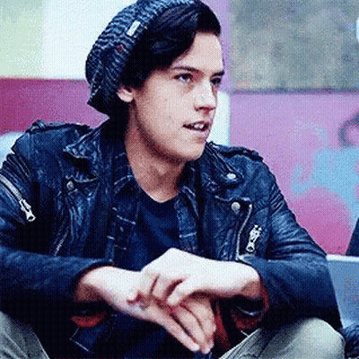Young Man In Leather Jacket And Beanie Sitting On Floor GIF