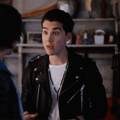 Young Man In Leather Jacket Talking To Another GIF