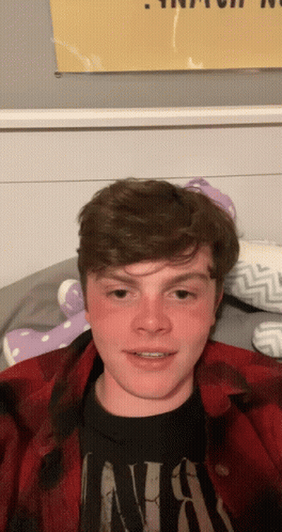 Young Man In Nirvana Shirt Laying On Bed GIF