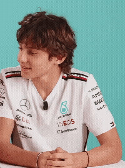 Young Man In Petronas Shirt At Desk GIF
