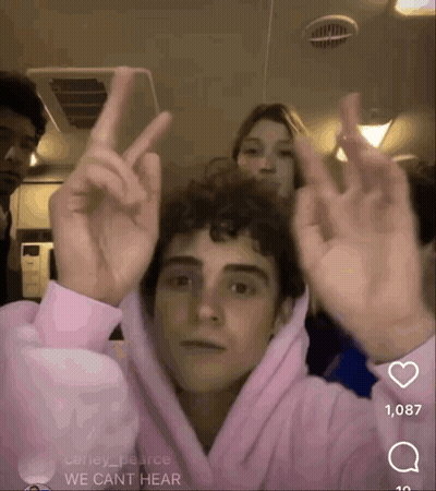 Young Man In Pink Hoodie Giving Peace Sign GIF