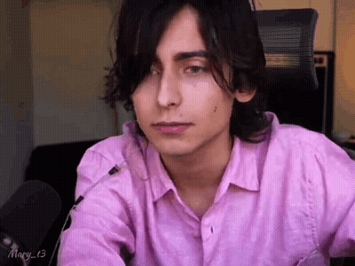 Young Man In Pink Shirt Sitting At Microphone GIF