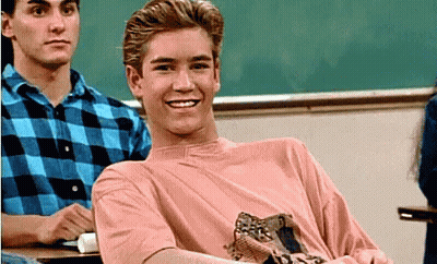 Young Man In Pink Shirt Smiling In Classroom GIF