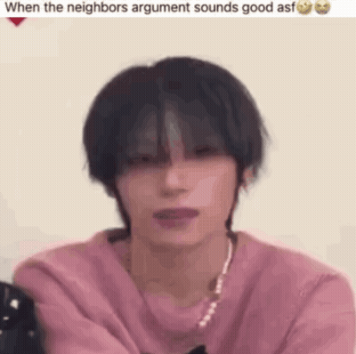 Young Man In Pink Sweater And Necklace Sitting GIF