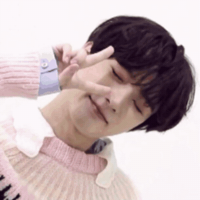 Young Man In Pink Sweater Making Peace Sign GIF