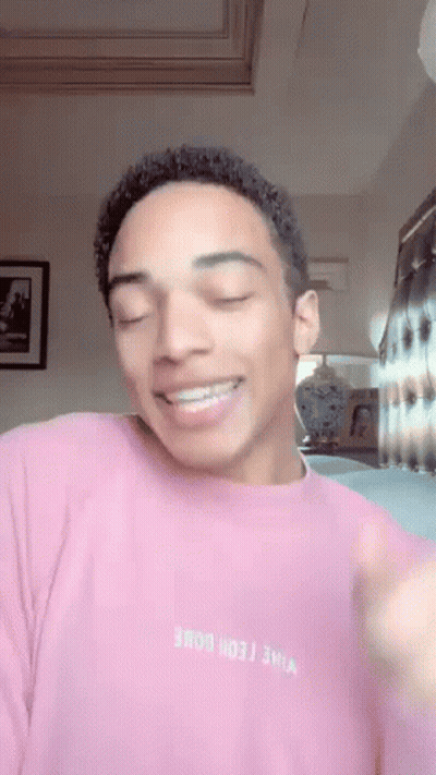 Young Man In Pink Sweater Smiling Making Funny Face GIF