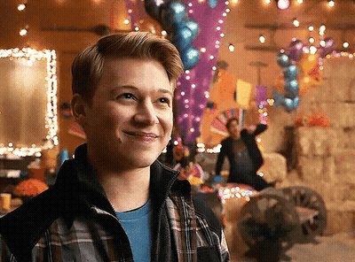 Young Man In Plaid Jacket Smiling With Balloons GIF