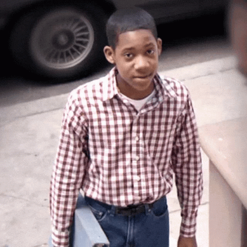 Young Man In Plaid Shirt And Jeans On Sidewalk GIF