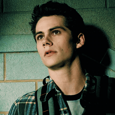 Young Man In Plaid Shirt Leaning Against Wall Looking Up GIF