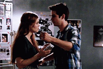 Young Man In Plaid Shirt Leaning Against Wall Looking Up GIF