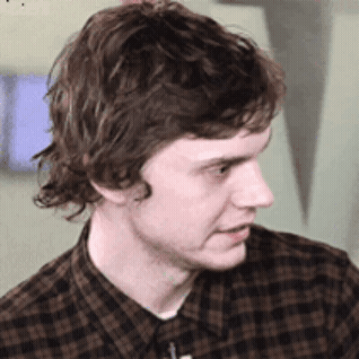 Young Man In Plaid Shirt Looking To Side GIF