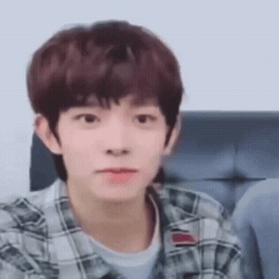Young Man In Plaid Shirt Making Funny Face On Couch GIF