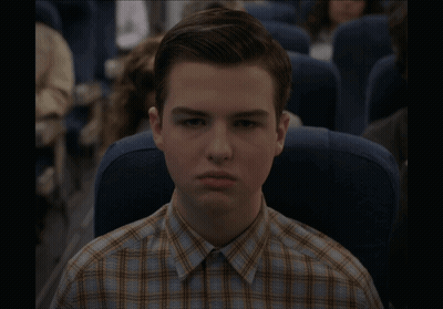 Young Man In Plaid Shirt Sitting On Plane GIF