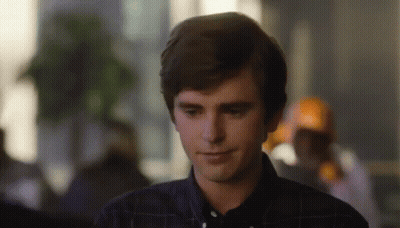 Young Man In Plaid Shirt Smiling Looking Down GIF