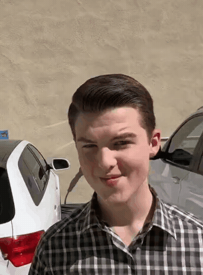 Young Man In Plaid Shirt Standing In Front Of Car GIF