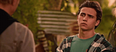 Young Man In Plaid Shirt Talking To Another Man By Car GIF
