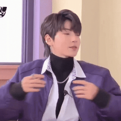 Young Man In Purple Jacket And Turtleneck Sitting GIF