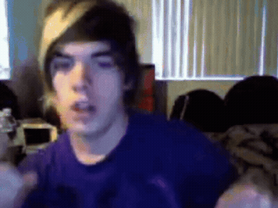 Young Man In Purple Shirt And Beanie Looking At Camera GIF