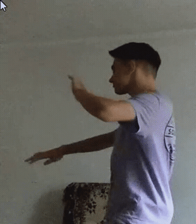 Young Man In Purple Shirt And White Shorts Standing In Front Of Couch GIF