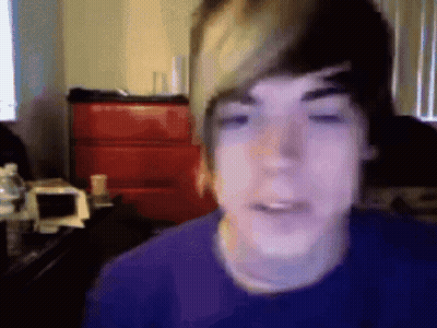 Young Man In Purple Shirt Looking At Camera GIF