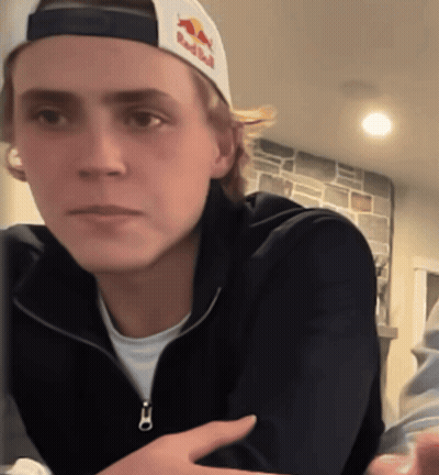 Young Man In Red Bull Hat Looking At Camera GIF