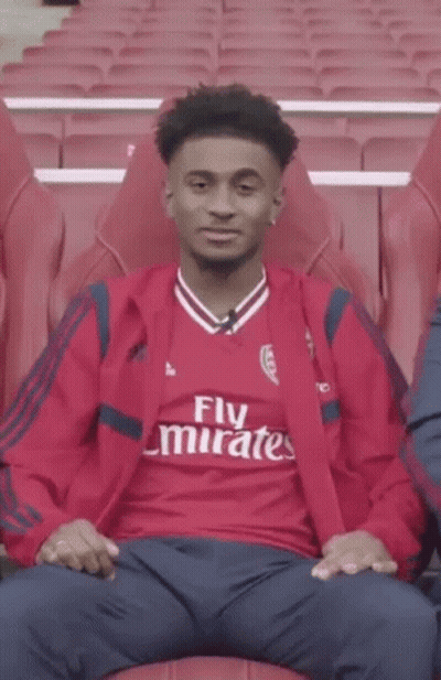 Young Man In Red Emirates Shirt Pointing GIF