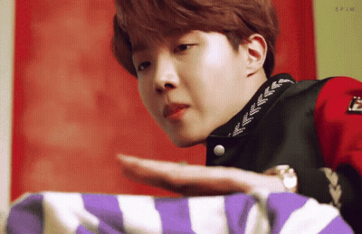 Young Man In Red Jacket Holding Purple And White Striped Blanket GIF