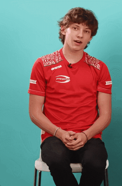 Young Man In Red Prestos Shirt Sitting GIF