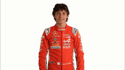 Young Man In Red Racing Suit Holding New Video Sign GIF