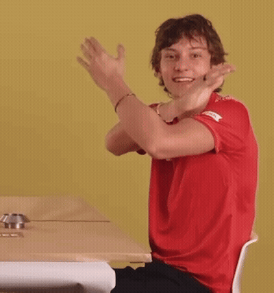 Young Man In Red Shirt Head Down At Table GIF