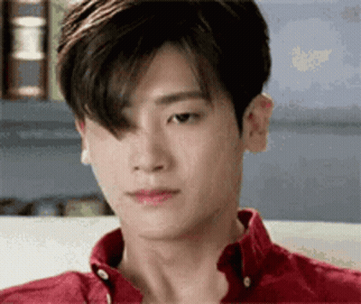 Young Man In Red Shirt Sitting On Couch Looking Down GIF