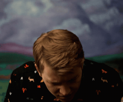 Young Man In Red Suit Waving At Microphone GIF