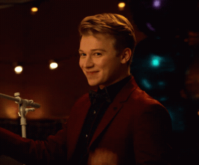 Young Man In Red Suit Waving At Microphone GIF