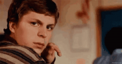 Young Man In Striped Shirt Looking At Camera GIF