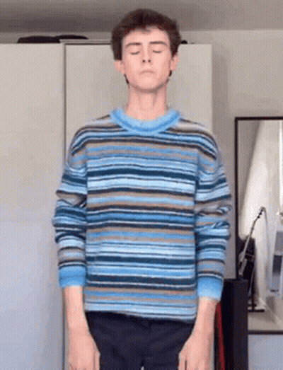 Young Man In Striped Sweater In Front Of Mirror GIF