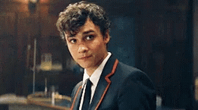 Young Man In Suit And Tie Looking At Camera In Dark Room GIF