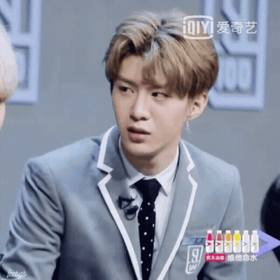 Young Man In Suit And Tie With Bottle Of Ioiyi GIF