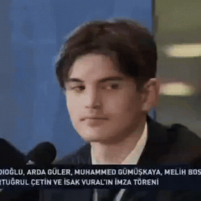 Young Man In Suit At Microphone GIF