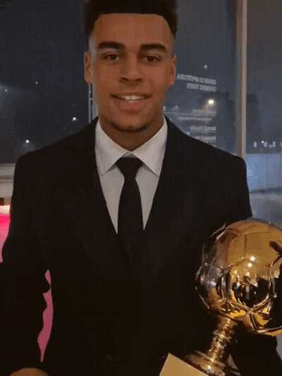 Young Man In Suit Holding Trophy GIF