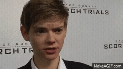Young Man In Suit In Front Of Maze Runner Sign GIF
