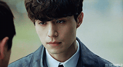 Young Man In Suit Looking At Another Man's Face GIF