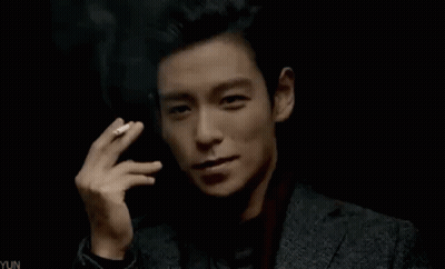 Young Man In Suit Smoking Cigarette In Dark Room GIF