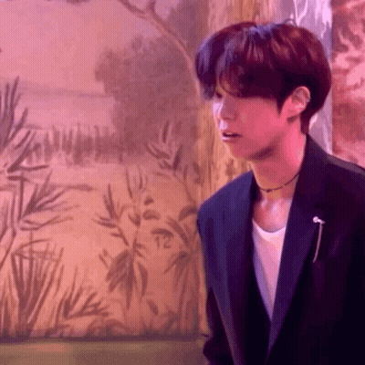 Young Man In Suit Standing Before Wall Painting GIF
