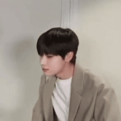Young Man In Suit Standing By Door GIF